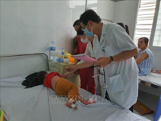 Bác sĩ Chuyên khoa II Huỳnh Hùng Dũng – Trưởng khoa Truyền nhiễm, Bệnh viện Nhi đồng thành phố Cần Thơ thăm khám cho một bệnh nhi bị bệnh tay chân miệng. Ảnh: Ánh Tuyết – TTXVN Cảnh báo bệnh tay chân miệng gia tăng nhanh ở Đồng bằng sông Cửu Long ảnh 1