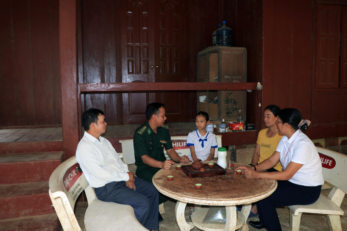 Cán bộ Đồn Biên phòng Chiềng Tương cùng giáo viên đến nhà thăm hỏi, động viên học sinh được hỗ trợ. Ảnh: Hữu Quyết - TTXVN "Chắp cánh" cho học sinh nghèo vùng biên Sơn La ảnh 3