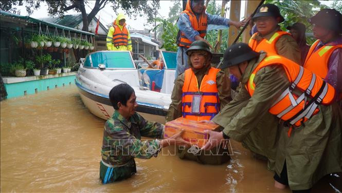 Lực lượng công an tỉnh Thừa Thiên - Huế trao tặng mì tôm cho các gia đình vùng trũng. Ảnh: TTXVN phát Người dân Thừa Thiên - Huế gồng mình chống lũ lớn ảnh 1
