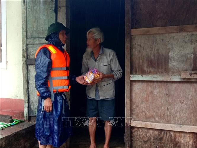 Lãnh đạo UBND xã Quảng Phước, huyện Quảng Điền tặng mì tôm cho bà con khó khăn. Ảnh: TTXVN phát Người dân Thừa Thiên - Huế gồng mình chống lũ lớn ảnh 2