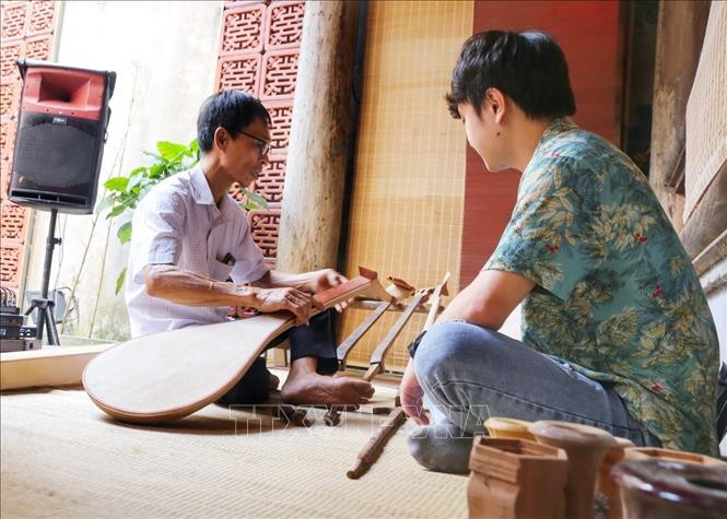 Nghệ nhân Đào Anh Tuấn, con trai nghệ nhân Đào Soạn (làng nghề Đào Xá) giới thiệu về các nhạc cụ tại triển lãm. Ảnh: Tuấn Đức - TTXVN Phố cổ Hà Nội ngân vang nhạc cụ truyền thống làng Đào Xá ảnh 1