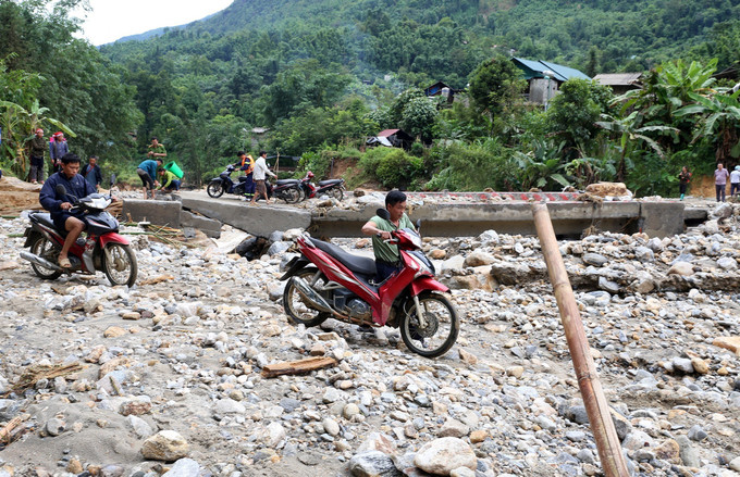 Người dân trong thôn Nậm Cang 1 (xã Liên Minh, thị xã Sa Pa, tỉnh Lào Cai) di chuyển khó khăn sau khi trận lũ đi qua. Ảnh: Quốc Khánh - TTXVN Lào Cai khẩn trương khắc phục hậu quả mưa lũ ảnh 1