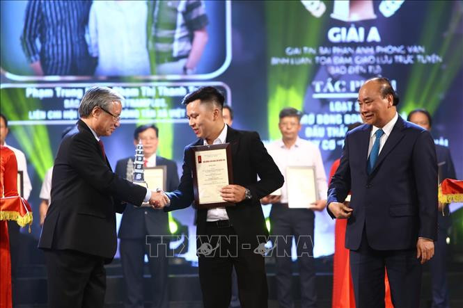 Thủ tướng Nguyễn Xuân Phúc và đồng chí Trần Quốc Vượng, Ủy viên Bộ Chính trị, Thường trực Ban Bí thư trao giải A cho đại diện nhóm tác giả có tác phẩm đoạt giải A thuộc Chi hội Nhà báo Báo điện tử VietnamPlus (Liên Chi hội Nhà báo TTXVN). Ảnh: Minh Quyết – TTXVN Lễ trao Giải Báo chí Quốc gia lần thứ XIV, năm 2019 ảnh 4