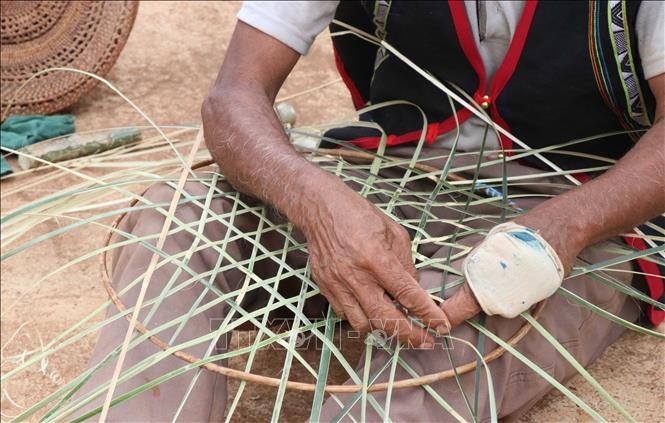 Đan áo mới của cồng, chiêng. Ảnh: Hồng Điệp – TTXVN Người Jrai may áo mới cho cồng, chiêng ảnh 7