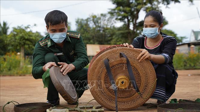 Lực lượng biên phòng Đồn Ia O, huyện Ia Grai (Gia Lai) giúp dân bảo tồn văn hóa bản địa. Ảnh: Hồng Điệp - TTXVN Người Jrai may áo mới cho cồng, chiêng ảnh 6