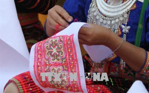 Những đôi tay khéo léo và tinh tế để thêu được những hoa văn tinh xảo lên trang phục. Ảnh: Xuân Tư – TTXVN Lào Cai có thêm 4 di sản văn hóa phi vật thể quốc gia ảnh 2