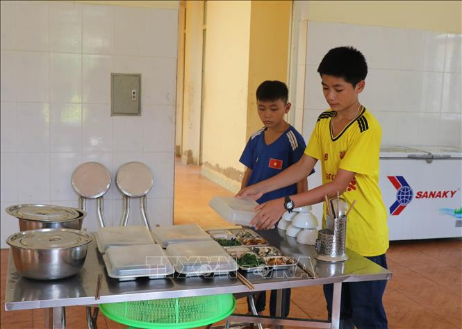 Cháu Quàng Trung Thành (phải) và Quàng Văn Kiên chuẩn bị mâm cơm trưa ăn cùng với các cán bộ, chiến sĩ Đồn Biên phòng Pa Thơm. Ảnh: Xuân Tiến – TTXVN Điện Biên chắp cánh ước mơ cho học sinh nghèo dân tộc thiểu số vùng biên ảnh 4
