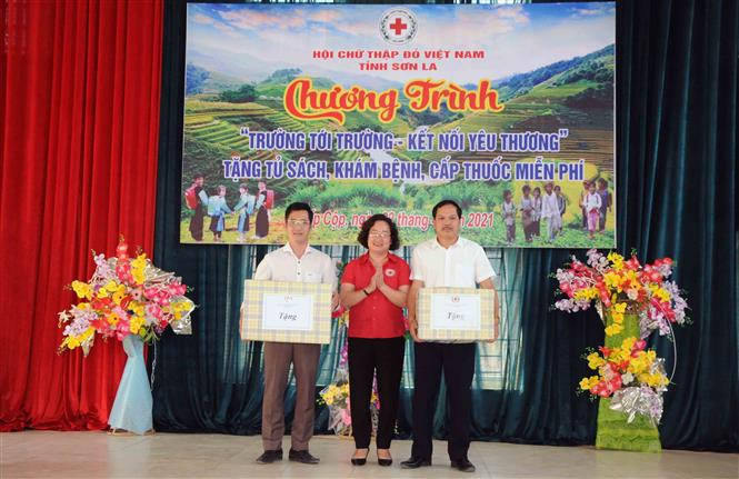 Chủ tịch Hội Chữ thập đỏ tỉnh Sơn La Cầm Thị Chuyên trao biểu trưng tủ sách cho Trường Phổ thông dân tộc nội trú THCS và THPT huyện Sốp Cộp và Trường bán trú Tiểu học và THCS Nậm Lạnh, huyện Sốp Cộp. Ảnh: Quang Quyết-TTXVN Sơn La: Hỗ trợ giáo viên, học sinh vùng sâu, vùng xa, biên giới có thêm điều kiện học tập, sinh hoạt ảnh 3