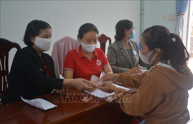Trao tiền hỗ trợ cho cho lao động từ vùng dịch về địa phương do bị mất thu nhập. Ảnh: Hoài Thu – TTXVN Đắk Lắk trao quà hỗ trợ cho lao động từ vùng dịch trở về địa phương ảnh 3