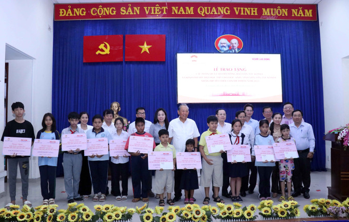 Ông Trương Hòa Bình, nguyên Ủy viên Bộ Chính trị, nguyên Phó Thủ tướng Thường trực Chính phủ và ông Nguyễn Văn Hiếu, Phó Bí thư Thành ủy Thành phố Hồ Chí Minh và đại diện nhà hảo tâm trao kinh phí hỗ trợ cho học sinh, sinh viên dân tộc Khmer có hoàn cảnh khó khăn. Ảnh: Xuân Khu-TTXVN Thành phố Hồ Chí Minh: Tặng quà cho đồng bào Khmer nhân dịp Tết cổ truyền Chol Chnam Thmey ảnh 2