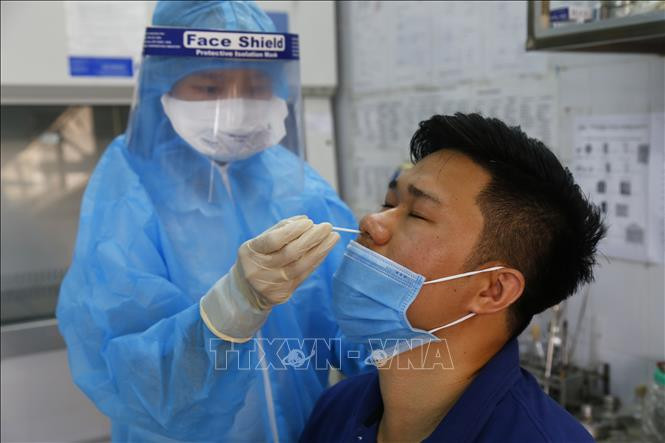 Lấy mẫu bệnh phẩm xét nghiệm Covid-19. Ảnh: Nam Sương - TTXVN Sẵn sàng trợ giúp địa phương trên toàn quốc để đảm bảo an toàn tiêm chủng vaccine phòng COVID-19 ảnh 3