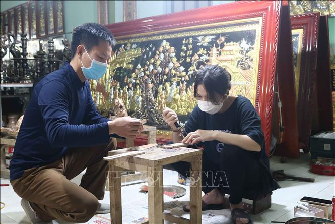 Nghệ nhân Nguyễn Văn Đông tại xã Đại Bái Gia Bình, Bắc Ninh) hướng dẫn cách làm sản phẩm khảm ngũ sắc cho công nhân. Ảnh: Thanh Thương - TTXVN Phát triển thương hiệu đồng Đại Bái ảnh 4