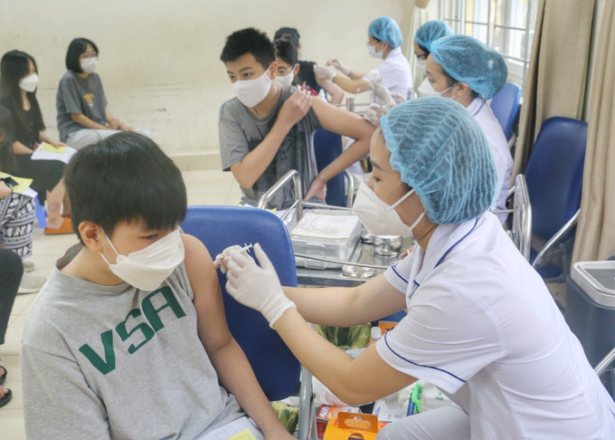 Nhân viên y tế phường Minh Khai tiêm mũi vaccine nhắc lại cho học sinh trường THCS Hà Huy Tập. Ảnh: Tuấn Đức - TTXVN Dịch COVID-19: Ngày 10/8, cả nước có 2.010 ca COVID-19 mới, thêm trên 438.000 liều vaccine được tiêm trong ngày ảnh 1