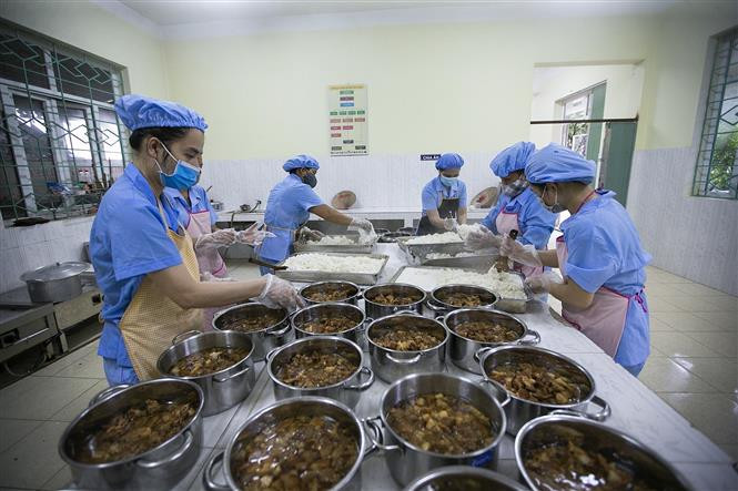 Các nhân viên phục vụ trong bếp ăn nhà trường luôn thực hiện đầy đủ các quy định về vệ sinh an toàn thực phẩm khi chế biến các món ăn. Ảnh: Trọng Đạt - TTXVN Hòa Bình nâng cao chất lượng bữa ăn bán trú trong các nhà trường ảnh 3