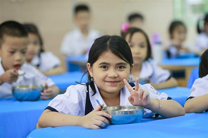 Nét rạng rỡ của một bạn nhỏ khối lớp 1 trong bữa ăn bán trú. Ảnh: Trọng Đạt - TTXVN Hòa Bình nâng cao chất lượng bữa ăn bán trú trong các nhà trường ảnh 5