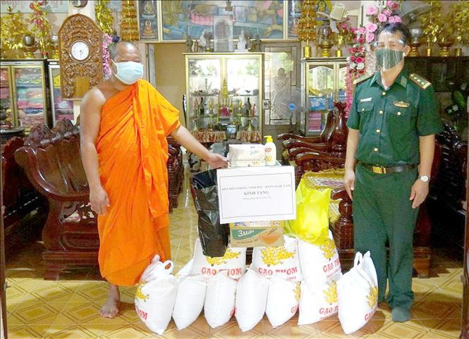 Bộ đội biên phòng Sóc Trăng trao tặng quà hỗ trợ nhà chùa và người dân Khmer khu vực biên giới biển. Ảnh: TTXVN phát Phát huy vai trò công tác dân vận trong phòng, chống dịch COVID-19 ảnh 1
