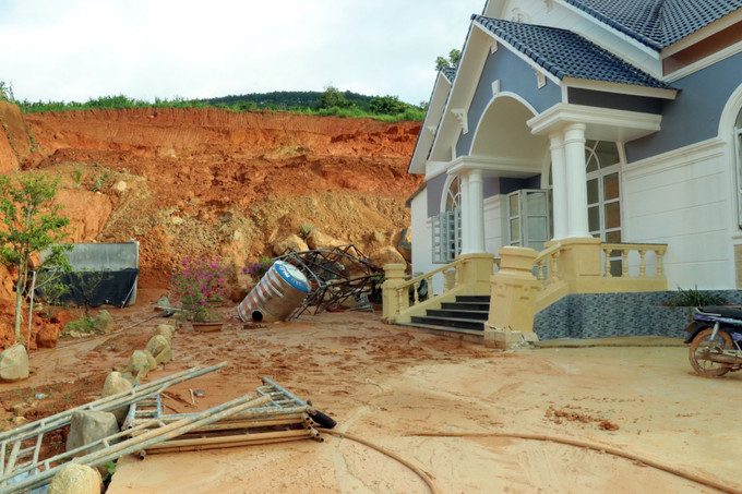 Đất đá từ ta luy dương sạt lở xuống phía sau căn nhà ven hồ. Ảnh: Nguyễn Dũng-TTXVN Sự cố sạt trượt công trình hồ Đông Thanh: Giải quyết nhu cầu cấp bách cho dân ảnh 4