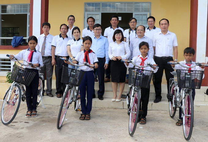 Đại diện chính quyền địa phương cùng Chi hội Nhà báo thường trú và các nhà tài trợ tặng xe đạp cho học sinh ở điểm trường thôn Hòa Ngãi (xã Sơn Định). Ảnh: Xuân Triệu - TTXVN Trao tặng giếng nước sạch và hàng trăm suất quà cho học sinh huyện miền núi ở Phú Yên ảnh 4