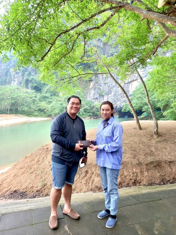 Du khách vui mừng và bày tỏ sự cảm ơn khi được nhân viên Trung tâm Du lịch Phong Nha - Kẻ Bàng trao trả lại tài sản bị quên, thất lạc. Ảnh: TTXVN phát Xây dựng Phong Nha trở thành điểm đến thân thiện và an toàn ảnh 7