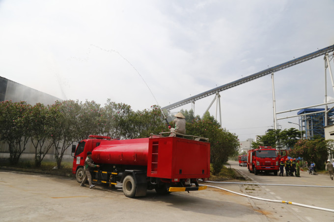Huy động phương tiện chữa cháy tại chỗ phối hợp dập tắt đám cháy. Ảnh: Nam Sương - TTXVN Tuyên Quang: Huấn luyện và diễn tập phương án chữa cháy, cứu nạn, cứu hộ trong Khu công nghiệp ảnh 2