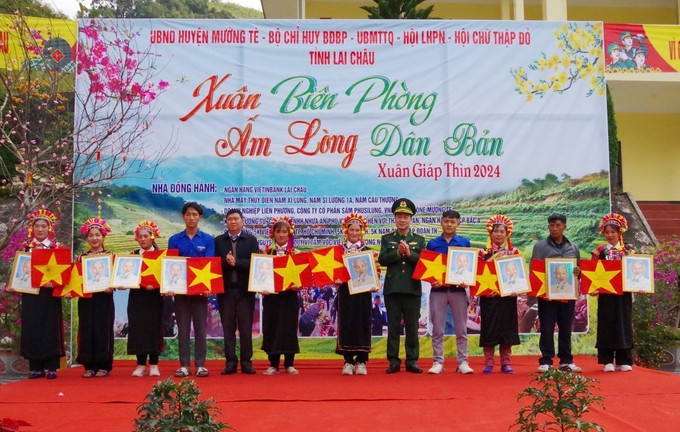 Tặng ảnh Bác Hồ và cờ Tổ quốc cho người dân biên giới bản Thò Ma, xã Pa Vệ Sủ. Ảnh: Nguyễn Oanh-TTXVN Quân dân biên giới Lai Châu đón Xuân sớm ảnh 7