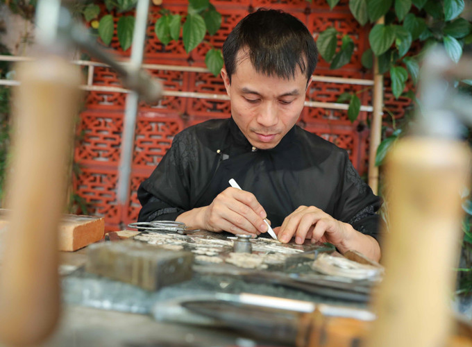 Trình diễn kỹ thuật nghề đậu bạc của nghệ nhân Quách Tuấn Anh (làng nghề kim hoàn Định Công) góp phần giữ gìn và phát huy bản sắc văn hóa truyền thống của dân tộc, quảng bá, tôn vinh những giá trị văn hóa của làng nghề Thủ đô. Ảnh: Thanh Tùng - TTXVN Làng nghề phát triển thúc đẩy kinh tế nông thôn ở Hà Nội ảnh 1