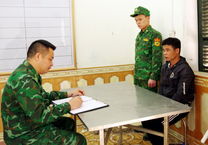 Lực lượng chức năng lấy lời khai đối tượng Tô Văn Trúc. Ảnh: Thái Thuần – TTXVN Khởi tố 5 đối tượng về hành vi tổ chức nhập cảnh trái phép ảnh 1