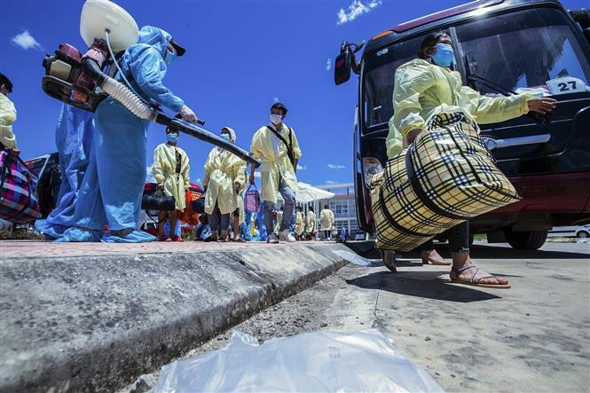 Công tác phun khử khuẩn được thực hiện ngay khi xe chở lao động về nơi tập kết trung chuyển. Ảnh: Trọng Đạt - TTXVN Hòa Bình đón 778 lao động từ Bắc Giang trở về địa phương ảnh 6