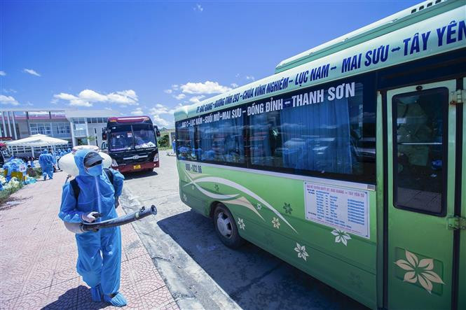Công tác phun khử khuẩn được thực hiện ngay khi xe chở lao động về nơi tập kết trung chuyển. Ảnh: Trọng Đạt - TTXVN Hòa Bình đón 778 lao động từ Bắc Giang trở về địa phương ảnh 7
