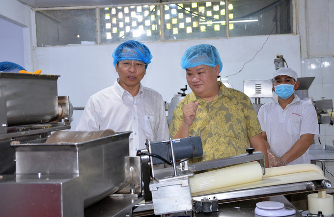 Phó Chủ tịch UBND tỉnh Sóc Trăng Vương Quốc Nam khảo sát cơ sở sản xuất bánh pía trên địa bàn tỉnh. Ảnh: Tuấn Phi - TTXVN Sóc Trăng hỗ trợ phát triển sản phẩm công nghiệp nông thôn tiêu biểu ảnh 1
