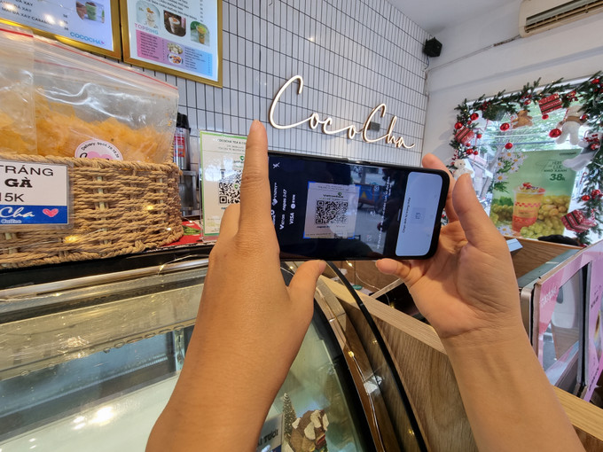 Khách hàng chuyển tiền nhanh từ quét mã QR. Ảnh: Nguyễn Thành – TTXVN Ninh Thuận chuyển đổi số để tạo nền tảng phát triển bền vững ảnh 1