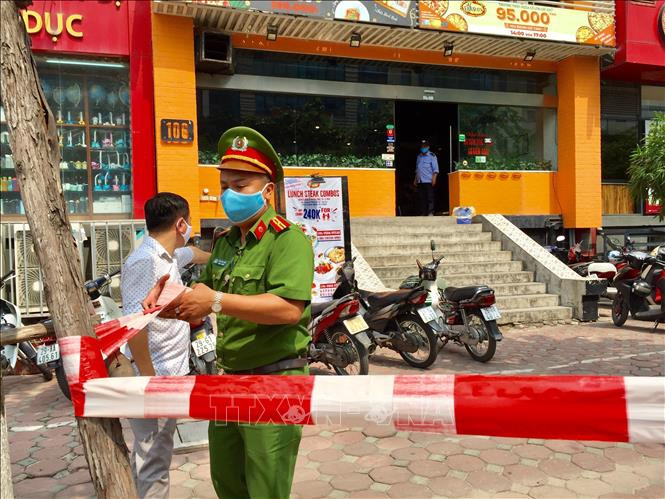 Công an phường Dịch Vọng Hậu căng dây "phong tỏa" khu vực nhà hàng bán Pizza 106 Trần Thái Tông. Ảnh: Nguyễn Thắng - TTXVN Hà Nội phong tỏa ngõ 230/26 Mễ Trì Thượng và một nhà hàng pizza vì có trường hợp nghi mắc COVID-19 ảnh 3