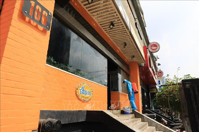 Nhân viên y tế phun thuốc tiêu độc khử trùng tại nhà hàng Pizza 106 Trần Thái Tông. Ảnh: Thành Đạt - TTXVN Hà Nội phong tỏa ngõ 230/26 Mễ Trì Thượng và một nhà hàng pizza vì có trường hợp nghi mắc COVID-19 ảnh 2