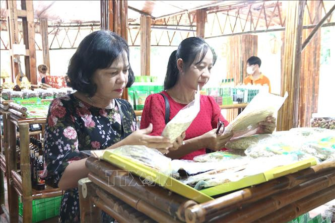 Đại biểu tham quan, tìm hiểu các sản phẩm OCOP và đặc sản tại Cửa hàng ở Khu di tích Ao Bà Om. Ảnh: Thanh Hòa- TTXVN Trà Vinh hỗ trợ xây dựng cửa hàng giới thiệu và kinh doanh sản phẩm OCOP ảnh 1