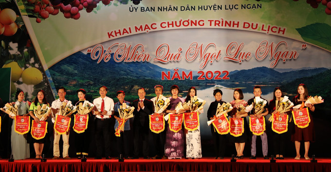Trao cờ lưu niệm cho các doanh nghiệp, hợp tác xã du lịch có đóng góp cho du lịch của huyện. Ảnh: Danh Lam –TTXVN Khai mạc Tuần lễ du lịch "Về miền quả ngọt" năm 2022 ảnh 5