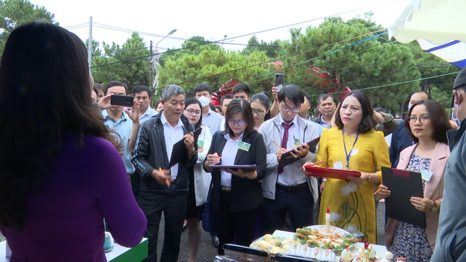 Ban giám khảo chấm thi các gian hàng trưng bày sản phẩm của các đơn vị. Ảnh: Hoài Nam - TTXVN Gia Lai lần đầu tổ chức hội thi sản phẩm nông sản tiêu biểu ảnh 1