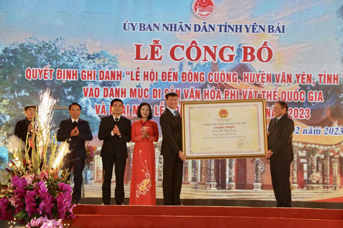 Uỷ viên Trung ương Đảng, Bộ trưởng Bộ Văn hoá, Thể thao và Du lịch Nguyễn Văn Hùng (bên phải) trao chứng nhận “Lễ hội Đền Đông Cuông, huyện Văn Yên, tỉnh Yên Bái” là Di sản văn hóa phi vật thể quốc gia cho đại diện tỉnh Yên Bái. Ảnh: Tuấn Anh - TTXVN Lễ công bố ghi danh Lễ hội đền Đông Cuông vào danh mục Di sản Văn hóa phi vật thể Quốc gia ảnh 1