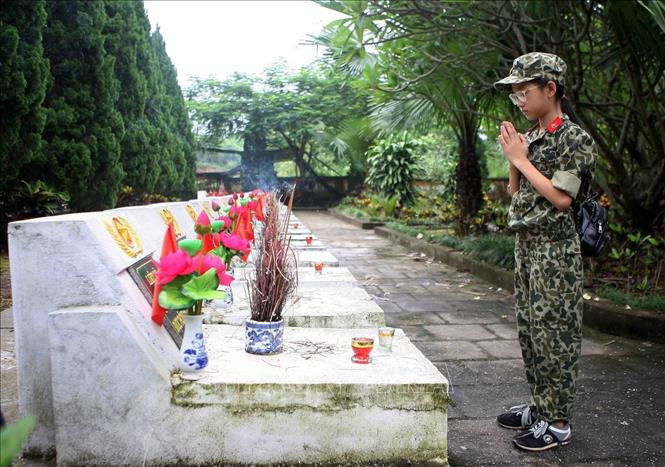 Thế hệ trẻ tưởng nhớ các anh hùng liệt sỹ đã hy sinh bảo vệ Tổ quốc, tại Nghĩa trang liệt sĩ quốc gia Vị Xuyên (Hà Giang). Ảnh: Thanh Tùng-TTXVN Kỷ niệm 43 năm Cuộc chiến đấu bảo vệ biên giới phía Bắc của Tổ quốc: Về đây đồng đội ơi (Bài cuối) ảnh 3