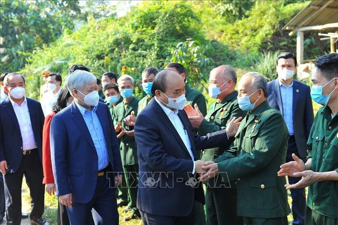 Chủ tịch nước Nguyễn Xuân Phúc thăm hỏi cựu chiến binh tại thôn Tân Bình, xã Việt Vinh, huyện Bắc Quang, tỉnh Hà Giang. Ảnh: Minh Đức – TTXVN Kỷ niệm 43 năm Cuộc chiến đấu bảo vệ biên giới phía Bắc của Tổ quốc: Về đây đồng đội ơi (Bài cuối) ảnh 1