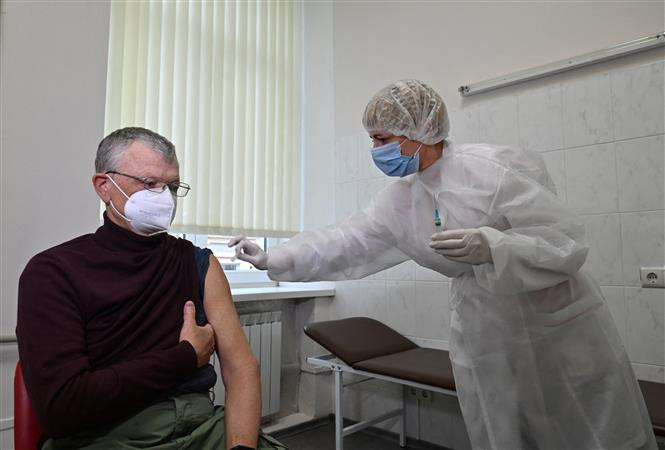 Nhân viên y tế tiêm vaccine ngừa COVID-19 cho người dân tại Kiev, Ukraine ngày 7/4/2021. Ảnh: AFP/TTXVN Nghiên cứu về khả năng mắc COVID-19 sau tiêm chủng chứng tỏ mức độ nguy hiểm của biến thể Delta ảnh 1