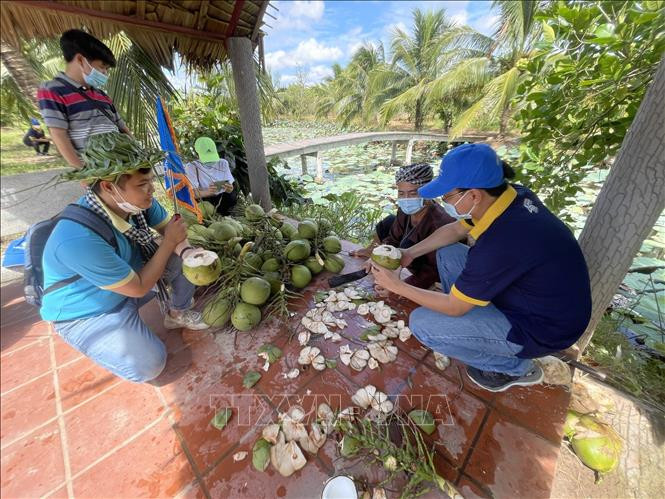 Du khách thưởng thức dừa Bến Tre. Ảnh: Huỳnh Phúc Hậu - TTXVN “Xứ Dừa” Bến Tre mở cửa đón khách du lịch nội địa ảnh 1