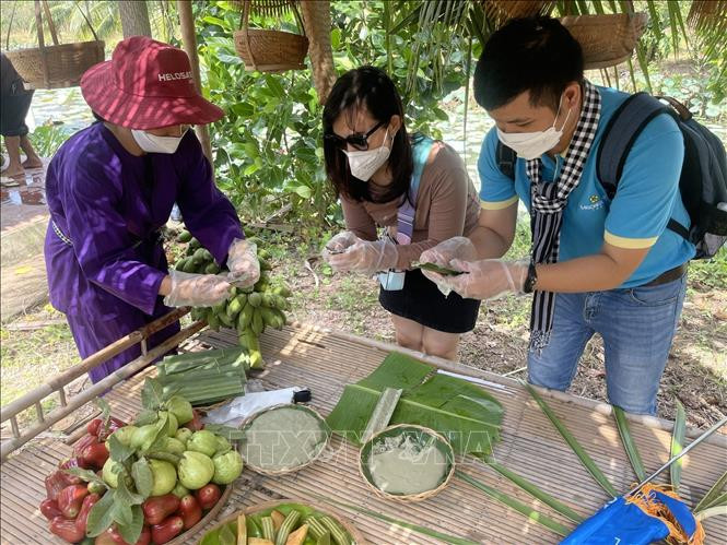 Du khách trải nghiệm du lịch tại "Xứ dừa" Bến Tre. Ảnh: Huỳnh Phúc Hậu - TTXVN “Xứ Dừa” Bến Tre mở cửa đón khách du lịch nội địa ảnh 2