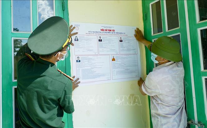 Cán bộ, chiến sĩ Biên phòng cùng chính quyền địa phương dán niêm yết danh sách người ứng cử Đại biểu Quốc hội khóa XV. Ảnh: Xuân Tư - TTXVN Điện Biên đảm bảo an ninh trật tự và công tác phòng dịch COVID-19 ở vùng biên ảnh 2