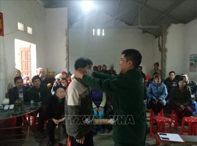 Bộ đội Biên phòng Đồn Biên phòng Cửa khẩu Lý Vạn (huyện Hạ Lang, tỉnh Cao Bằng) phát khẩu trang miễn phí và tuyên truyền về dịch bệnh do chủng mới virus Corona tới người dân. Ảnh: Chu Hiệu - TTXVN Vững vàng thế trận biên phòng toàn dân ảnh 4