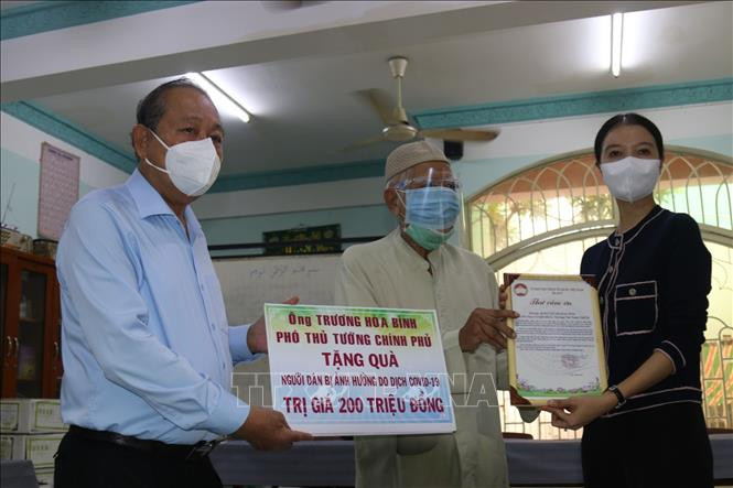 Phó Thủ tướng Thường trực Trương Hòa Bình thăm hỏi và trao quà cho người dân là đồng bào dân tộc Chăm tại Quận 8, TP.Hồ Chí Minh. Ảnh: Quang Châu - TTXVN Dịch COVID-19: Phó Thủ tướng Trương Hòa Bình tặng quà đồng bào Chăm tại Thành phố Hồ Chí Minh ảnh 2
