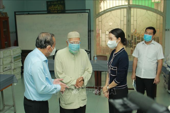 Phó Thủ tướng Thường trực Trương Hòa Bình thăm hỏi tình hình cuộc sống của đồng bào dân tộc Chăm tại Quận 8, TP.Hồ Chí Minh. Ảnh: Quang Châu - TTXVN Dịch COVID-19: Phó Thủ tướng Trương Hòa Bình tặng quà đồng bào Chăm tại Thành phố Hồ Chí Minh ảnh 1