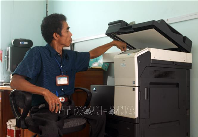 Anh Hán Văn Thư in tài liệu. Ảnh: Công Thử - TTXVN Nghị lực phi thường của chàng trai tật nguyền ở làng Chăm Hữu Đức ảnh 1