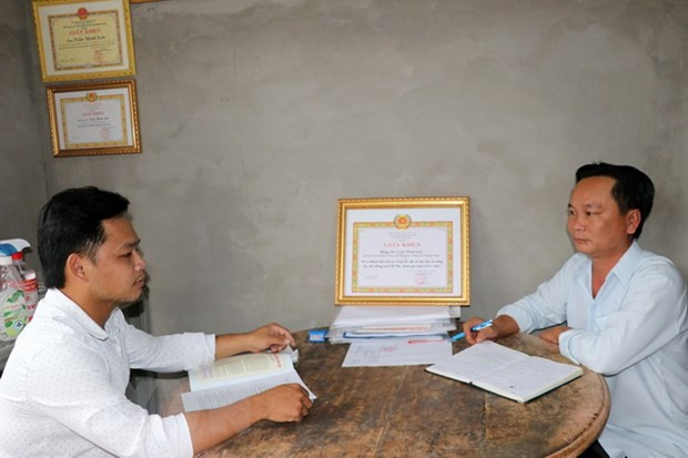 Bí thư ấp Hòa Quới Trần Minh Sơn (phải) trao đổi với cán bộ Tuyên giáo xã về công tác tuyên truyền. Ảnh: Hữu Chí - TTXVN 93 năm thành lập Đảng: Bí thư Chi bộ học tập và làm theo Bác ảnh 1