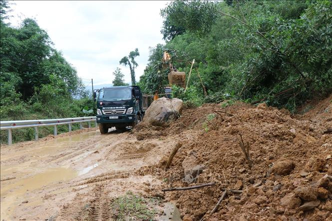 Khẩn trương dọn bùn, đất để người dân lưu thông trên đường tỉnh lộ 622B. Ảnh: Sỹ Thắng - TTXVN Quảng Ngãi khắc phục, thông tuyến các điểm sạt lở ở các huyện miền núi để người dân đi lại ảnh 1
