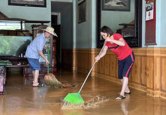 Các hộ gia đình tại xã Cốc San dọn nhà cửa do mưa lớn tràn vào trong nhà. Ảnh: Quốc Khánh - TTXVN Mưa lớn gây ngập cục bộ nhiều tuyến phố ở Lào Cai ảnh 6